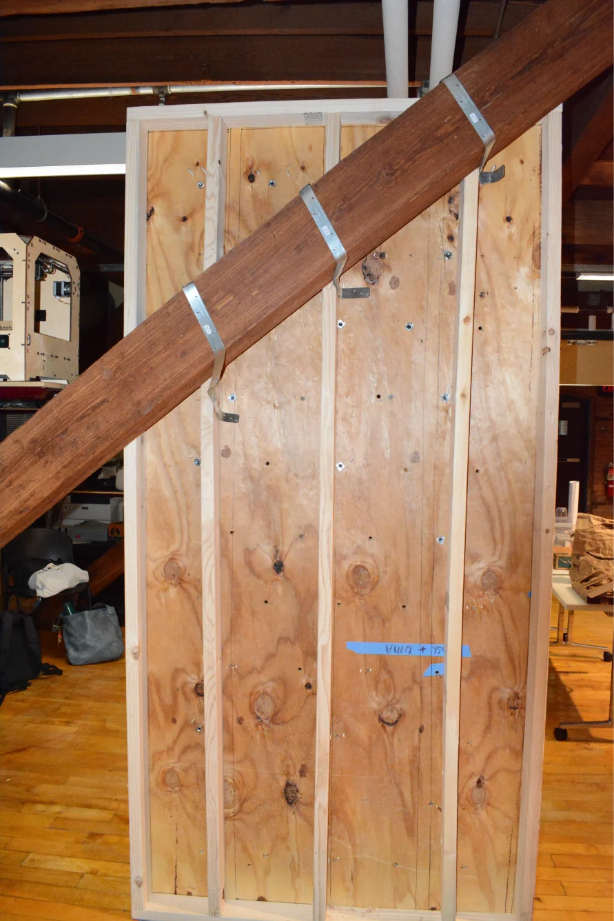 The back of the wall, mounted to a wooden beam with steel ties