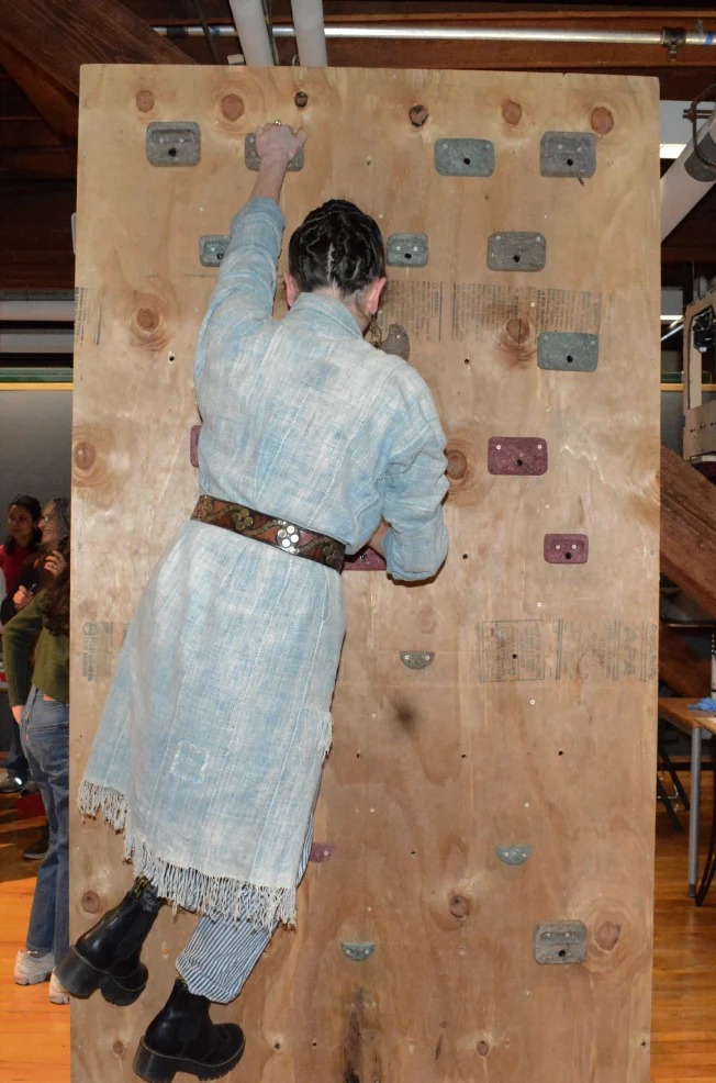 A climber in a long coat on the wall