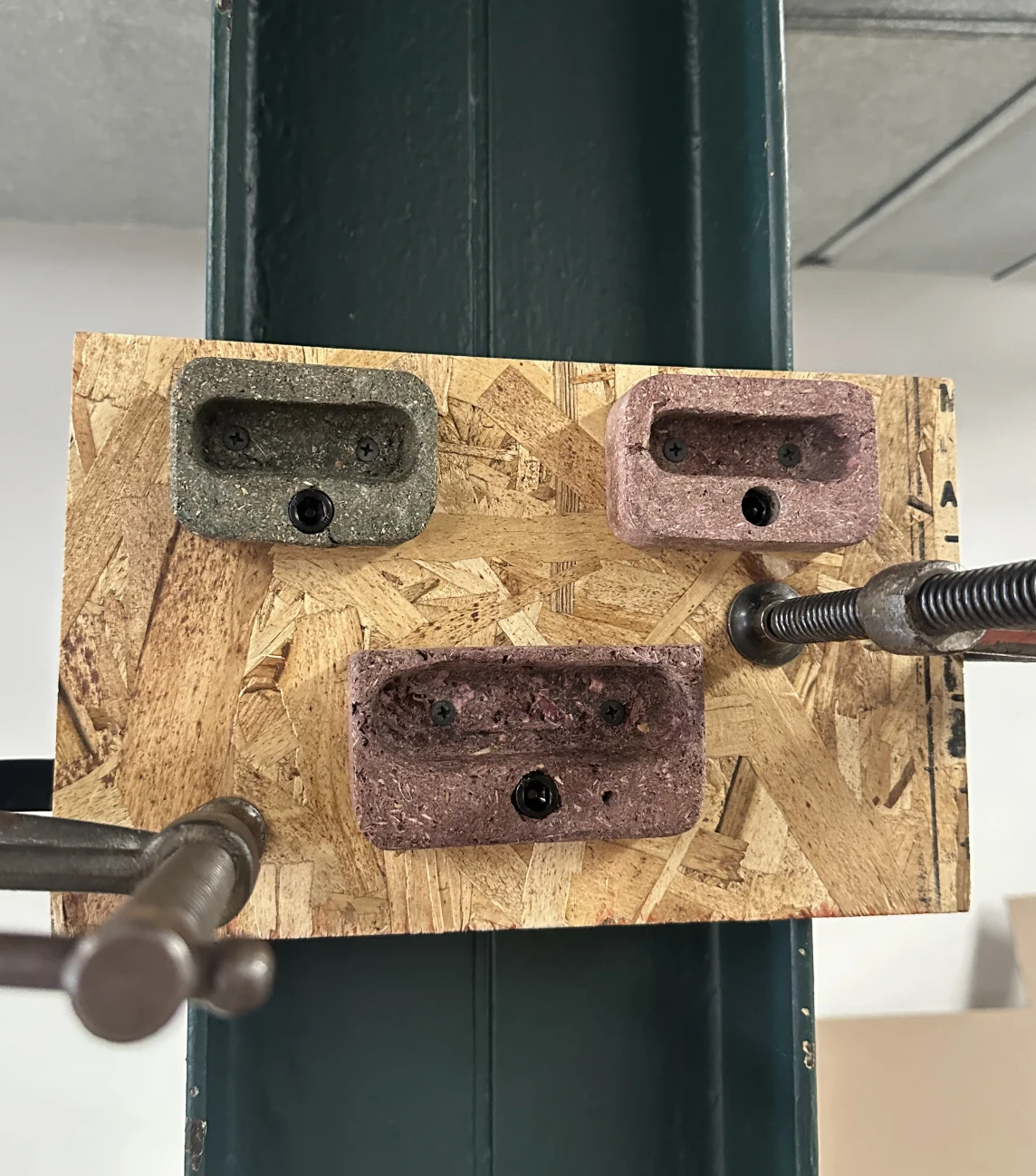 Three holds bolted to a sample board and clamped to a steel column